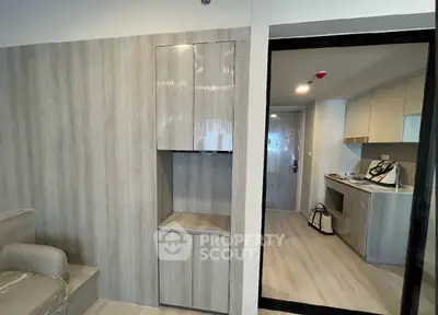 Modern apartment interior with sleek wooden cabinetry and open kitchen layout.