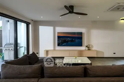 Modern living room with sleek design, large sofa, wall-mounted TV, and balcony access.