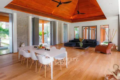 Luxurious open-plan living room with high wooden ceilings and modern furnishings, perfect for entertaining.