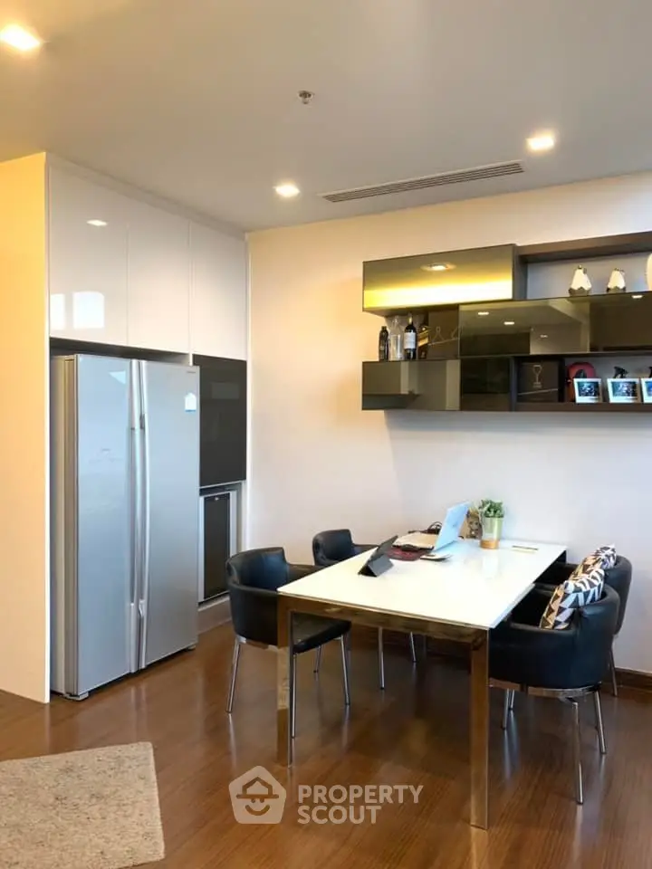 Modern kitchen with sleek dining area and stylish shelving in a contemporary apartment.