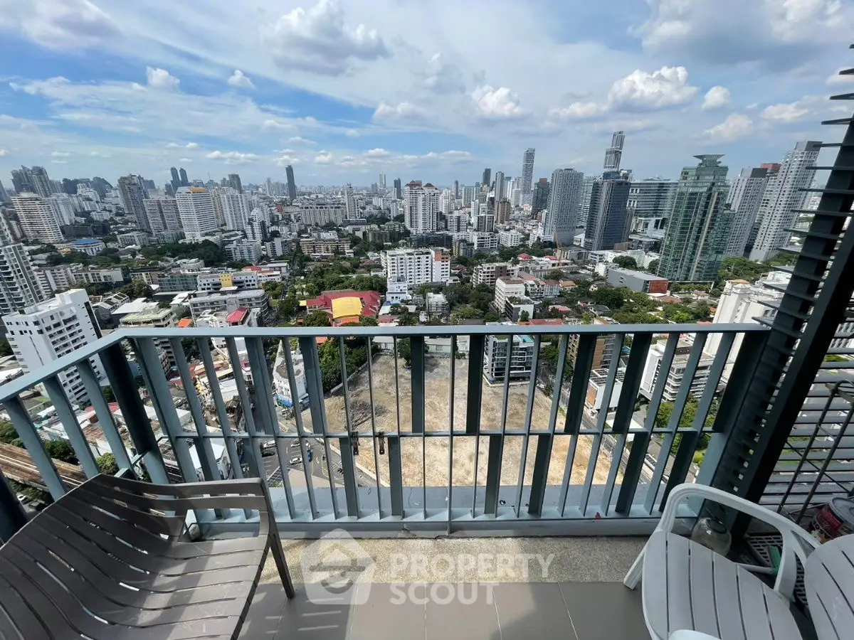 Stunning cityscape view from high-rise balcony with modern seating.
