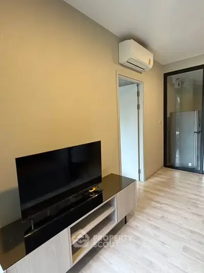 Modern living room with sleek TV stand and air conditioning in a stylish apartment.