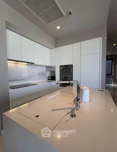 Modern kitchen with sleek white cabinets and island in luxury apartment