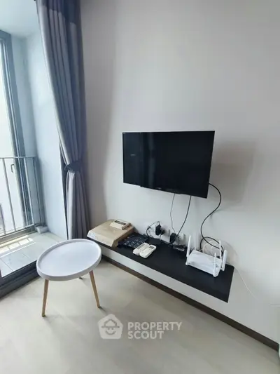 Modern living room with wall-mounted TV and balcony view