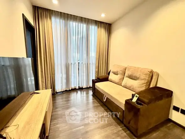 Cozy living room with plush sofa and modern TV setup, perfect for relaxation.