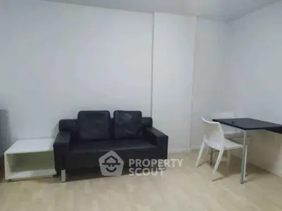 Modern minimalist living room with black sofa and dining table