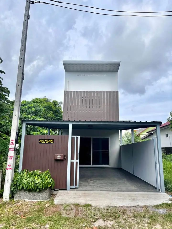 Modern two-story house with sleek facade and carport in a serene neighborhood.