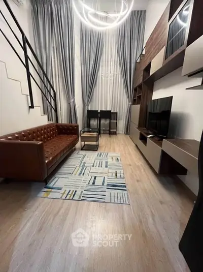 Modern living room with high ceilings, stylish furniture, and elegant lighting in a contemporary apartment.