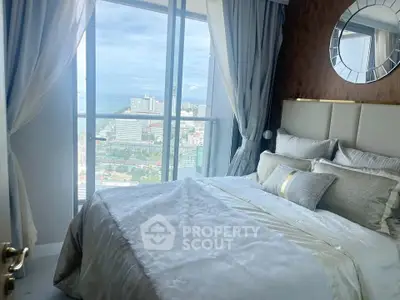 Luxurious bedroom with stunning city and ocean view from high-rise window.