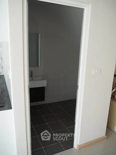 Modern bathroom with sleek sink and tiled floor in a contemporary home.