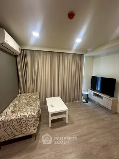 Modern living room with sleek furniture and large window drapes, featuring a cozy sofa and flat-screen TV.