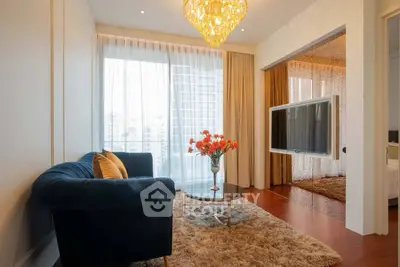 Luxurious living room with elegant chandelier and city view, featuring plush sofa and modern decor.