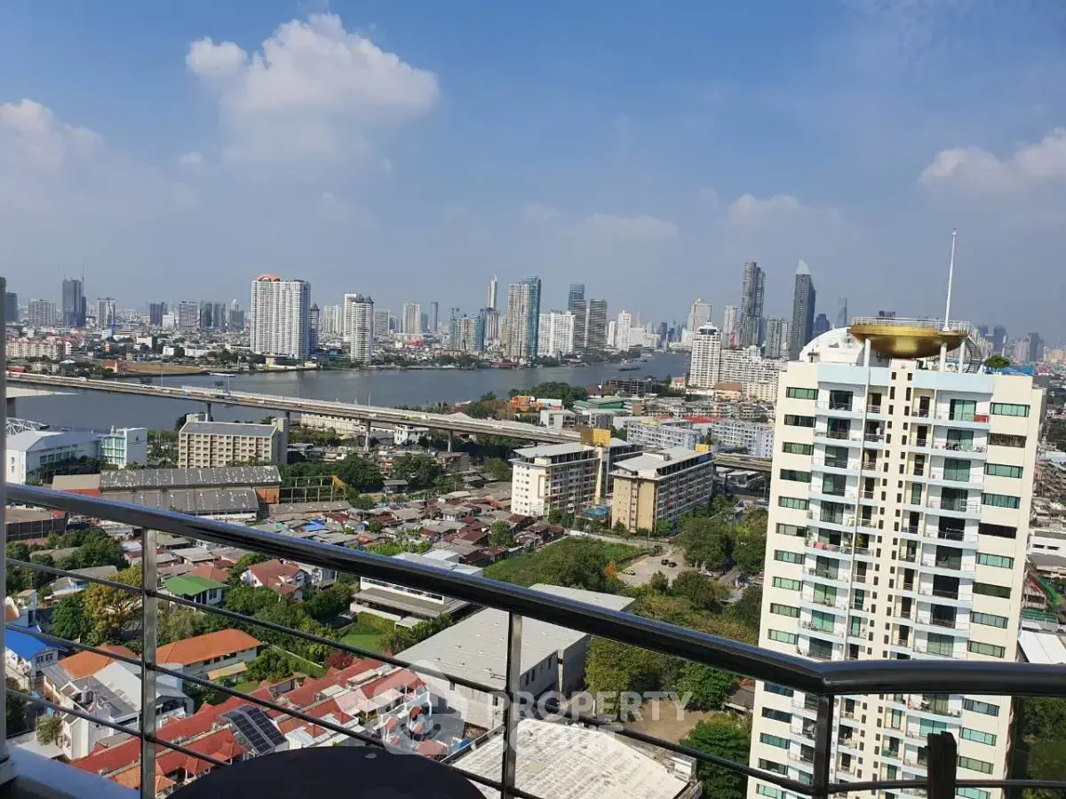 Stunning cityscape view from a high-rise balcony overlooking a river and skyline.
