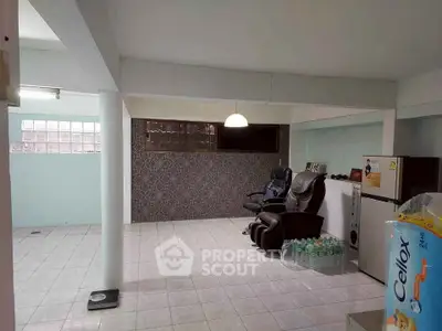 Spacious basement room with massage chairs and mini fridge, ideal for relaxation or entertainment.