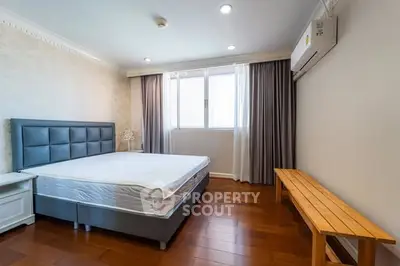 Spacious bedroom with wooden flooring and modern air conditioning unit