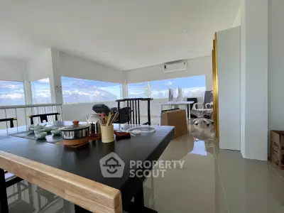 Spacious modern living room with panoramic windows and sleek furnishings, perfect for contemporary living.