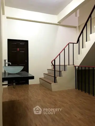 Spacious interior with modern staircase and wooden flooring, ideal for stylish living.