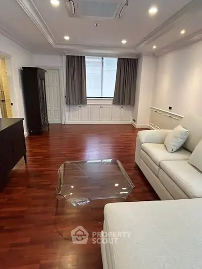 Spacious living room with elegant wooden flooring and modern furniture