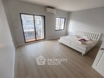 Spacious bedroom with large windows and modern air conditioning unit