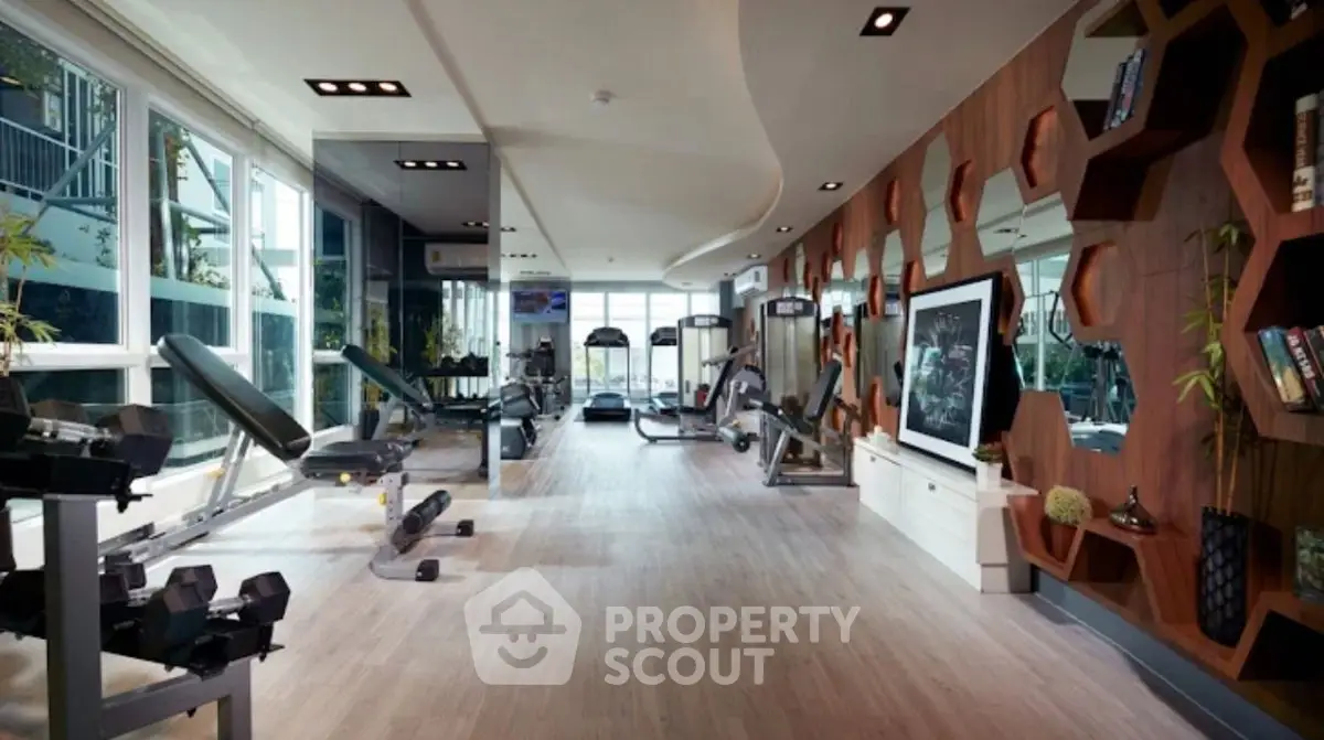 Luxurious modern gym with state-of-the-art equipment and stylish decor in a high-end residential building.