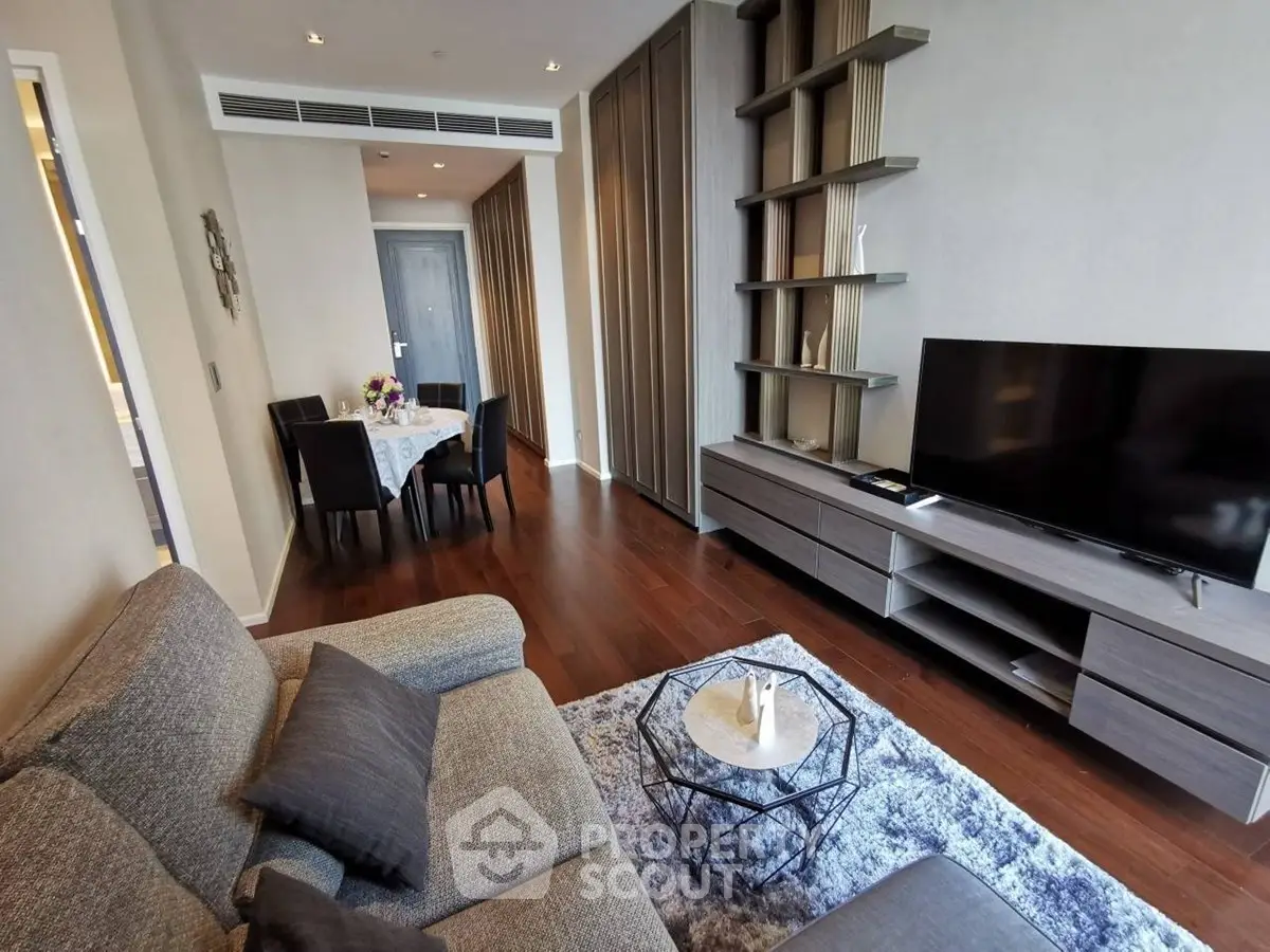 Modern living room with stylish furniture and open layout, featuring a cozy sofa and large TV.