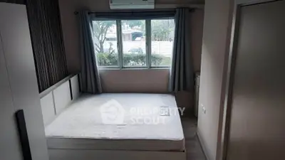 Cozy bedroom with large window and air conditioning, offering a serene view of the outdoors.