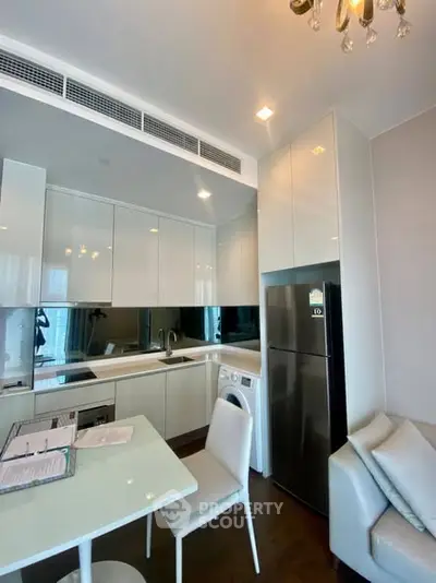 Modern kitchen with sleek cabinetry, integrated appliances, and cozy dining area in a stylish apartment.