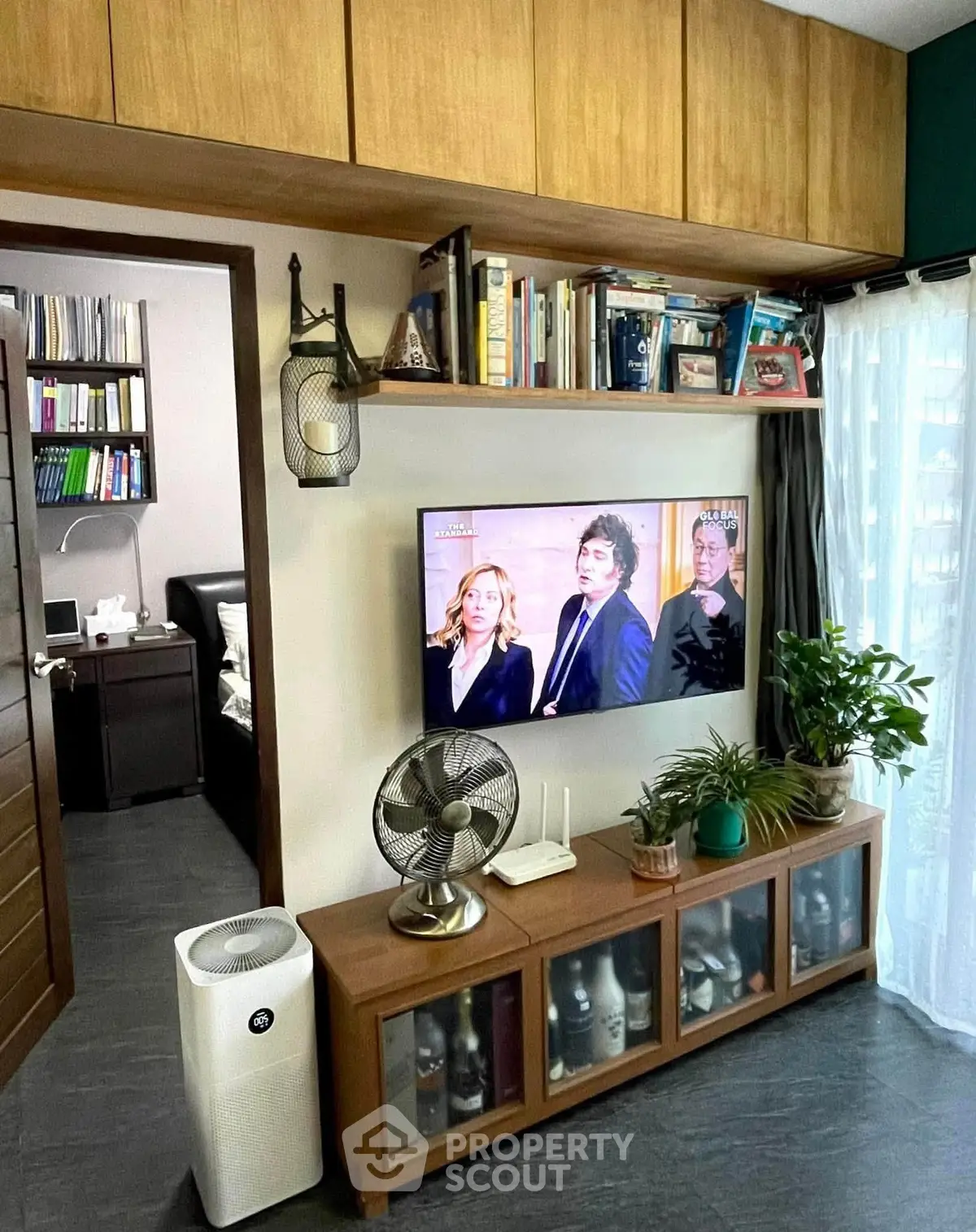 Stylish living room with modern decor, built-in shelves, and a wall-mounted TV, perfect for cozy relaxation.