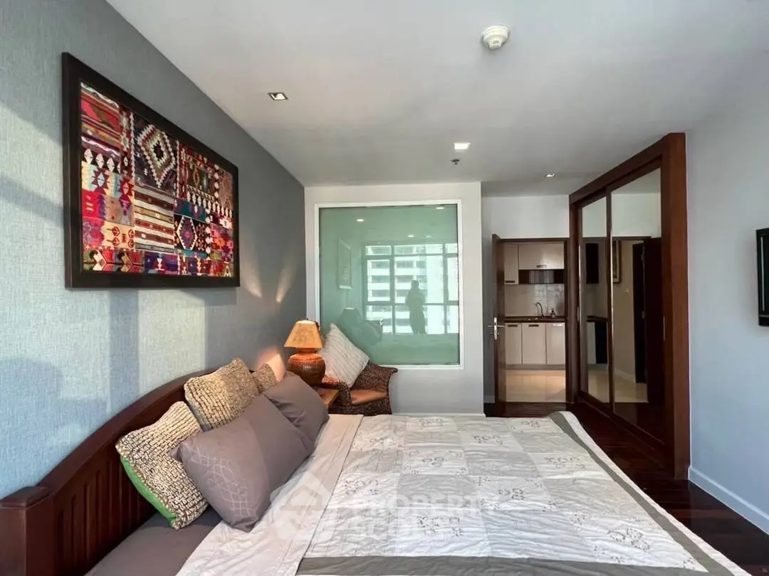 Spacious bedroom with modern decor and ample natural light in a stylish apartment.