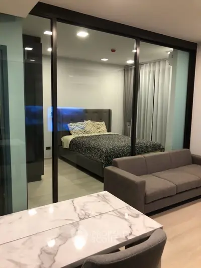Modern apartment with glass-walled bedroom and stylish living area