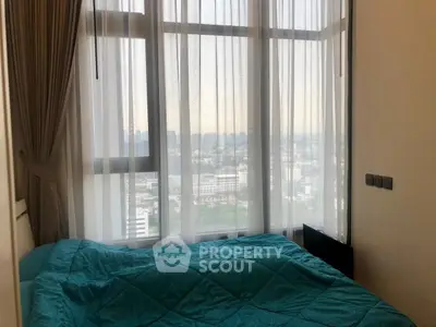 Cozy bedroom with large windows offering stunning city views