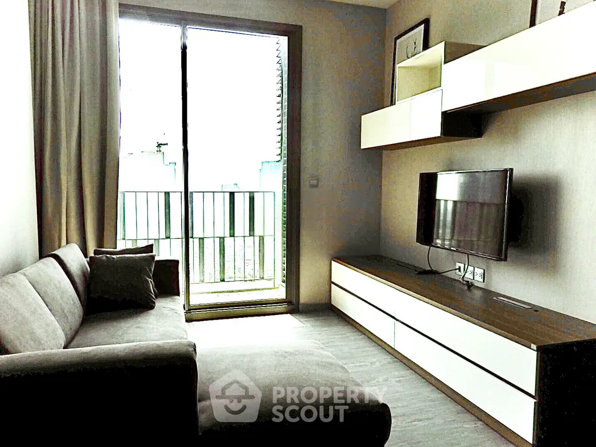 Modern living room with sleek furniture and balcony access, perfect for urban living.