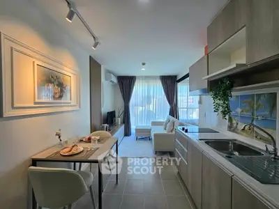 Modern open layout kitchen and living room with elegant decor and natural light.