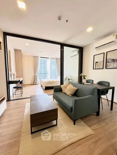 Modern open-plan living room with stylish furniture and large windows in a contemporary apartment.