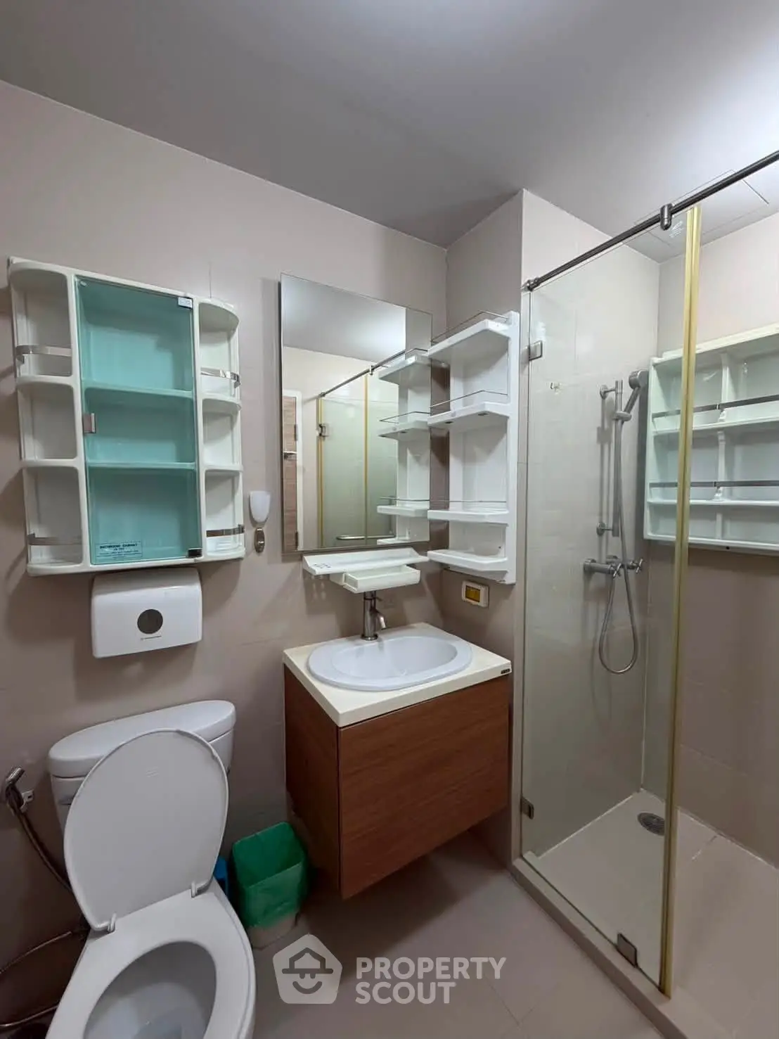 Modern bathroom with glass shower and sleek vanity in contemporary apartment.