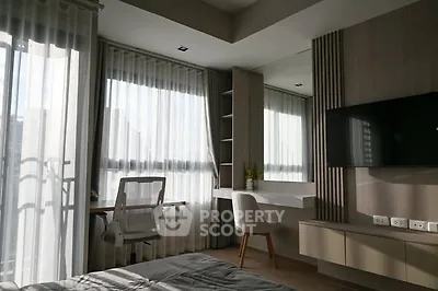 Modern bedroom with study area and large windows in a stylish apartment.