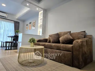 Modern living room with cozy brown sofa and stylish decor in a bright open layout.