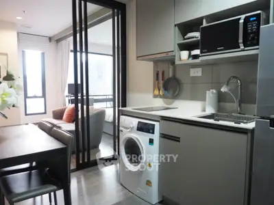 Modern kitchen with washing machine and open layout in stylish apartment