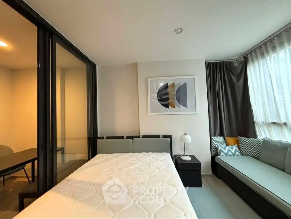 Modern bedroom with stylish decor and natural light, featuring a cozy bed and elegant furnishings.