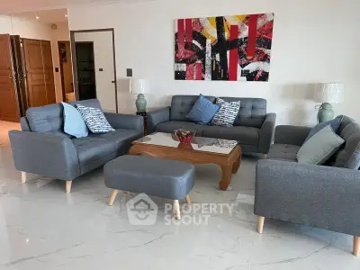 Stylish living room with modern gray sofas, abstract art, and elegant decor in a spacious interior.
