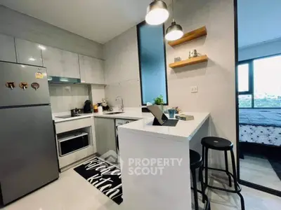 Modern kitchen with sleek design and open layout adjacent to cozy bedroom.