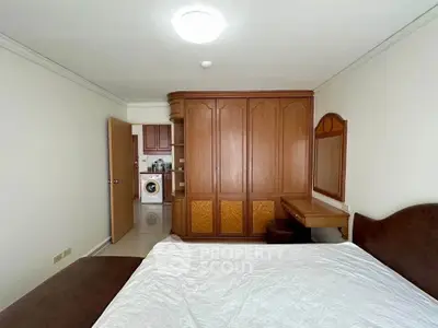 Spacious bedroom with built-in wardrobe and adjacent laundry area