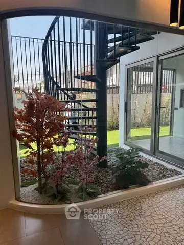 Modern interior with spiral staircase and indoor garden view