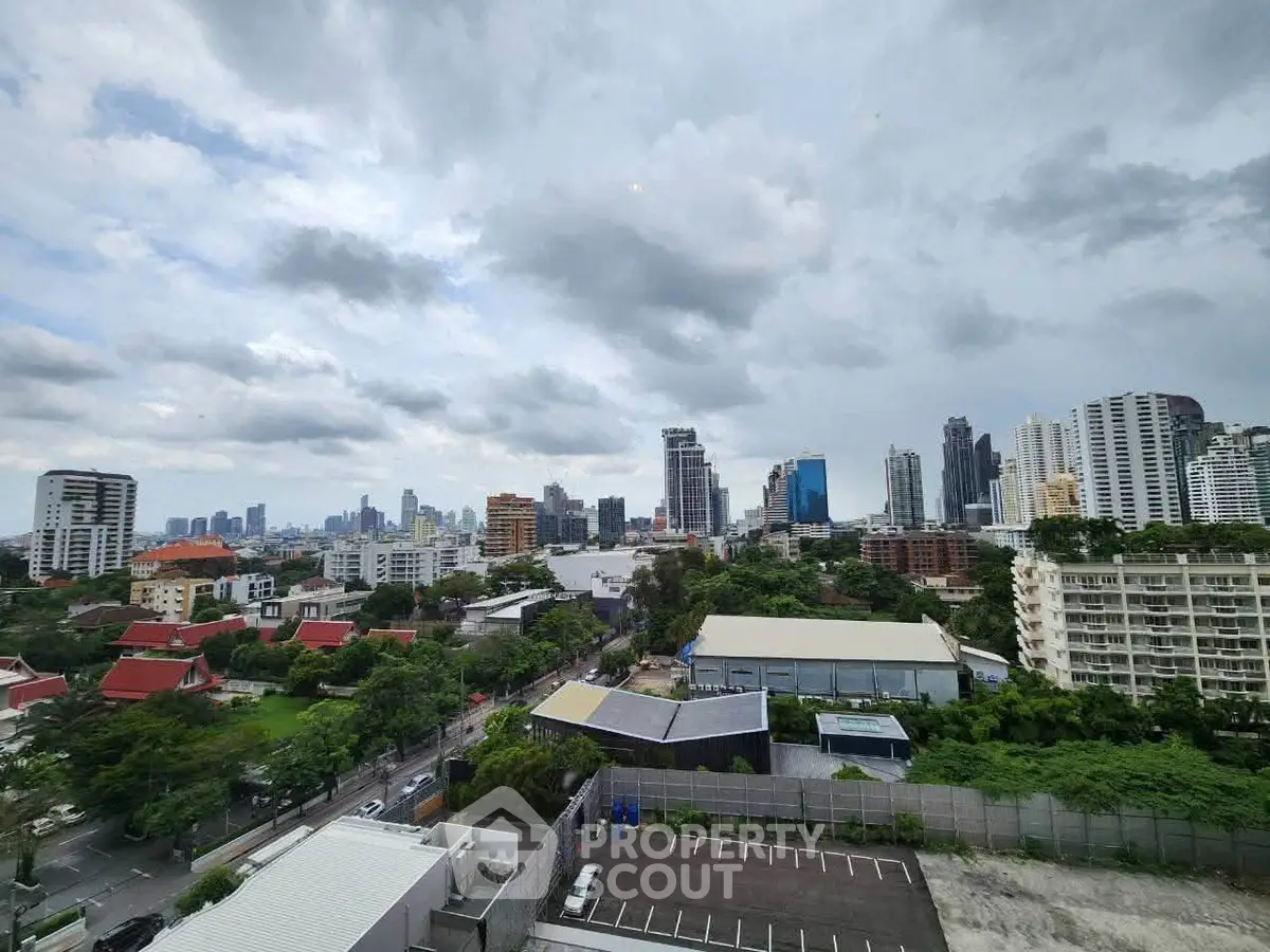 Stunning cityscape view from a high-rise building showcasing urban skyline and lush greenery.