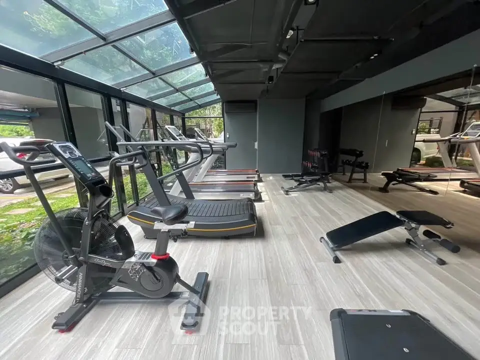 Modern gym with state-of-the-art equipment and glass ceiling for natural light.
