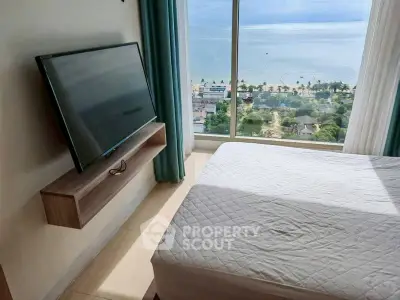 Stunning bedroom with ocean view and wall-mounted TV in modern apartment.