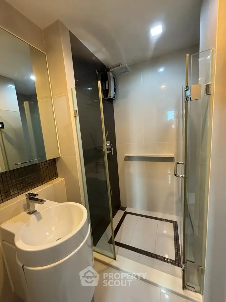 Modern bathroom with sleek shower and stylish sink in contemporary apartment.