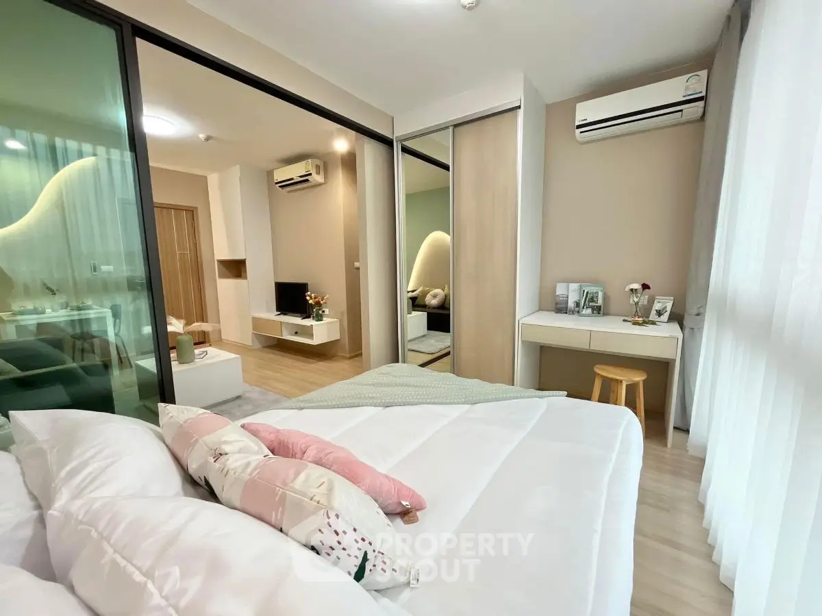 Modern bedroom with cozy decor and sliding glass doors to living area.