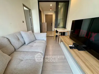 Modern living room with cozy sofa and large TV, perfect for relaxation and entertainment.