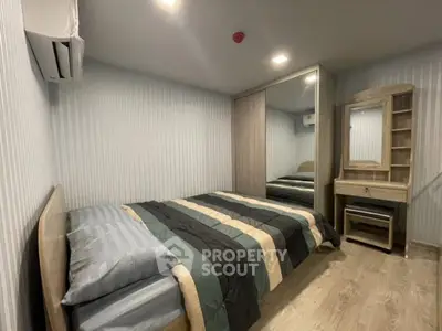 Cozy bedroom with modern decor and mirrored wardrobe in stylish apartment.